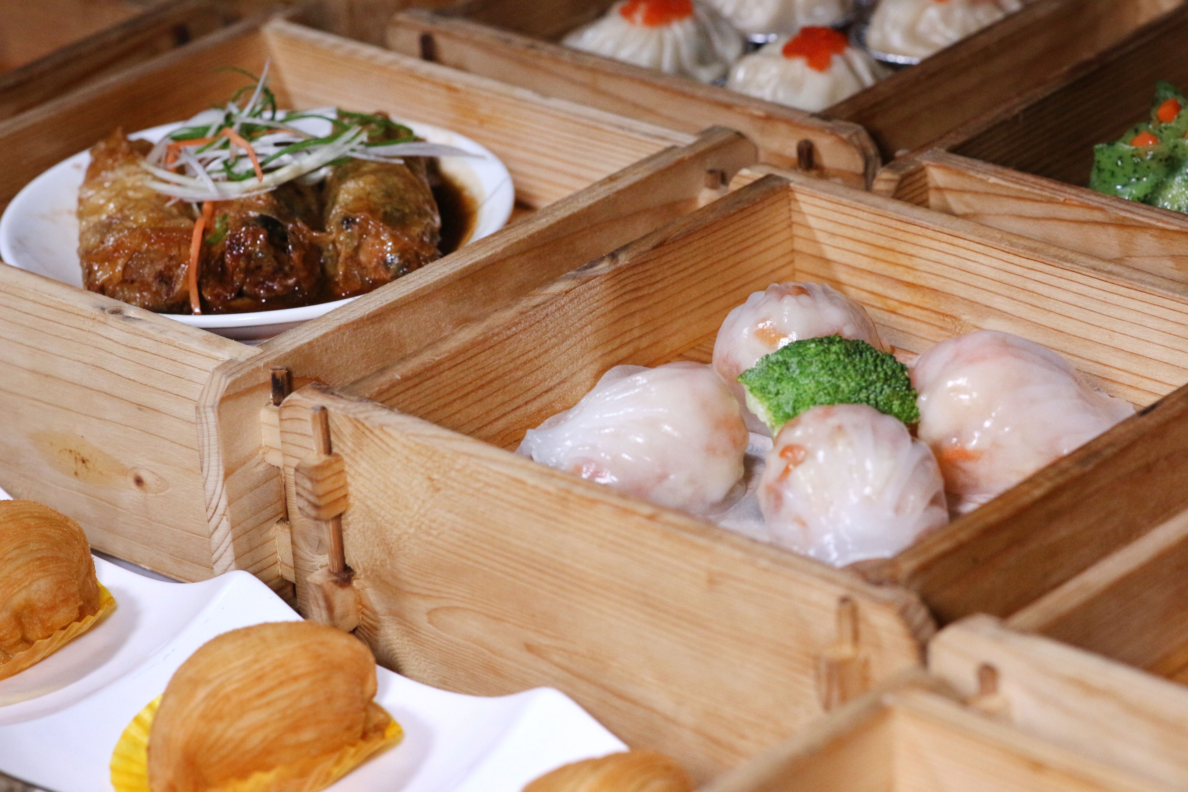 A variety of dim sum dishes in wooden boxes.