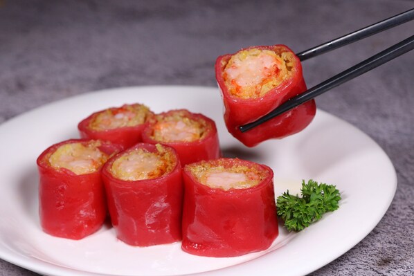 A plate of red stuffed peppers with a garnish of parsley. - Junluxe Hotel Guangzhou Zengcheng (Guangzhou)
