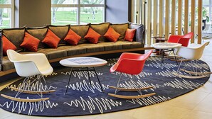 A modern lounge area with a sofa, rocking chairs, and a coffee table. - ibis Rio Branco (Rio Branco)