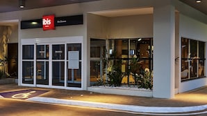A hotel entrance with a sign for 'ibis Hotels Rio Branco,' a wheelchair-accessible entrance, and a small outdoor area with plants. - ibis Rio Branco (Rio Branco)