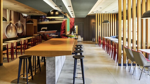 A modern restaurant interior with high tables, bar stools, and a long counter. - ibis Rio Branco (Rio Branco)