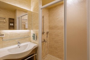 A bathroom with a sink, mirror, glass shower enclosure, and a towel rack. - Kindness Hotel Sanduo Shopping District (Kaohsiung)