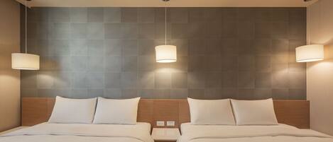 Quarto de hotel com duas camas, cabeceira de madeira e luminárias fixadas na parede.