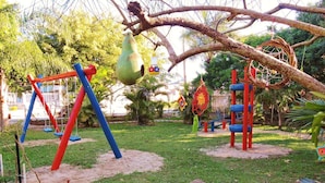 Un parque infantil con columpios, estructuras de escalada y adornos colgantes.