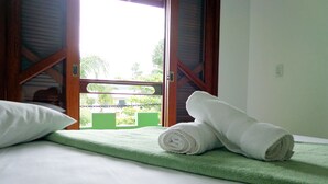 Una habitación de hotel con una cama, almohadas y toallas enrolladas.
