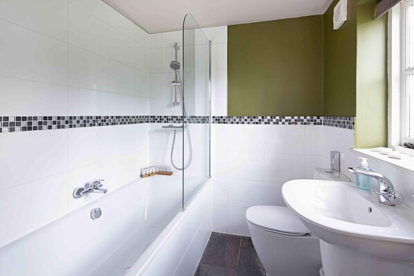 A modern bathroom with a glass-enclosed shower, a white sink, and a toilet.