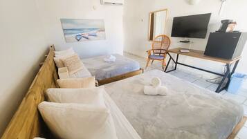 Une chambre d’hôtel avec un lit, un bureau, une chaise, une télévision et un tableau au mur.