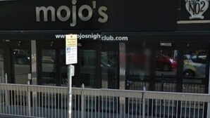 A storefront with the sign "mojo's" and a website address "www.mojosnightclub.com". - Hotel Belmonte (Norwich)