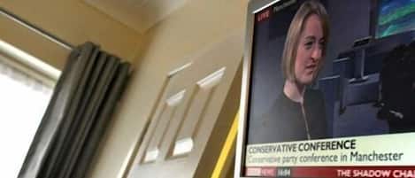 A television screen displaying a news broadcast about the Conservative Conference in Manchester.