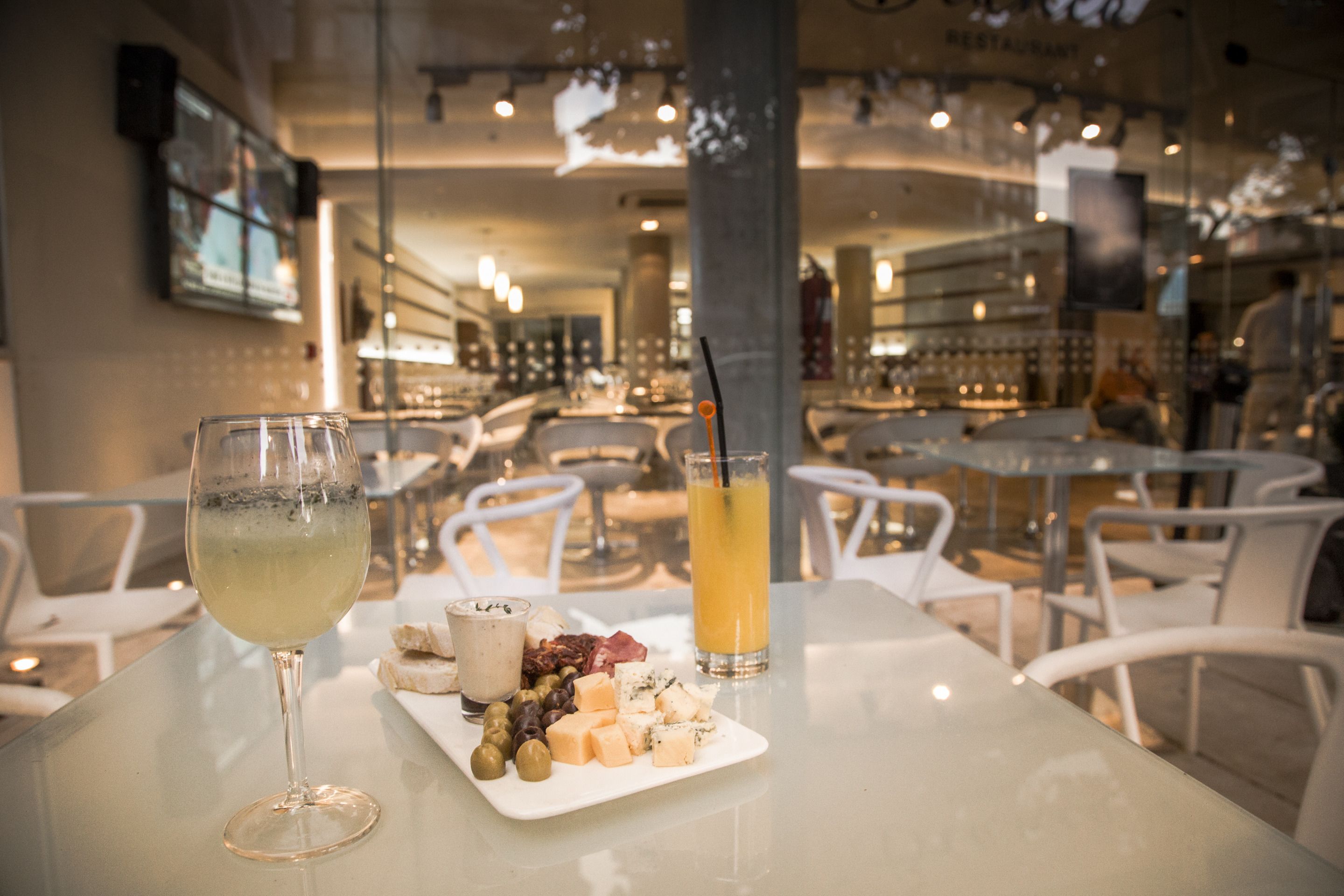 L’intérieur d’un restaurant, avec des tables, des chaises et une vitrine.