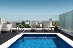 A rooftop pool with clear blue water, surrounded by lounge chairs and a glass barrier. - Vivaldi Hotel Loft Punta Carretas (Montevideo)