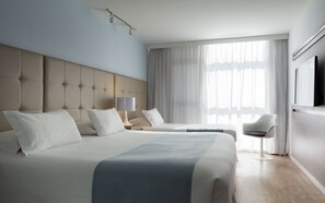 A modern hotel room with a large bed, a bedside table, a chair, and a TV. - Vivaldi Hotel Loft Punta Carretas (Montevideo)