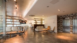 A modern lobby with a reception desk, seating area, and an elevator. - Vivaldi Hotel Loft Punta Carretas (Montevideo)