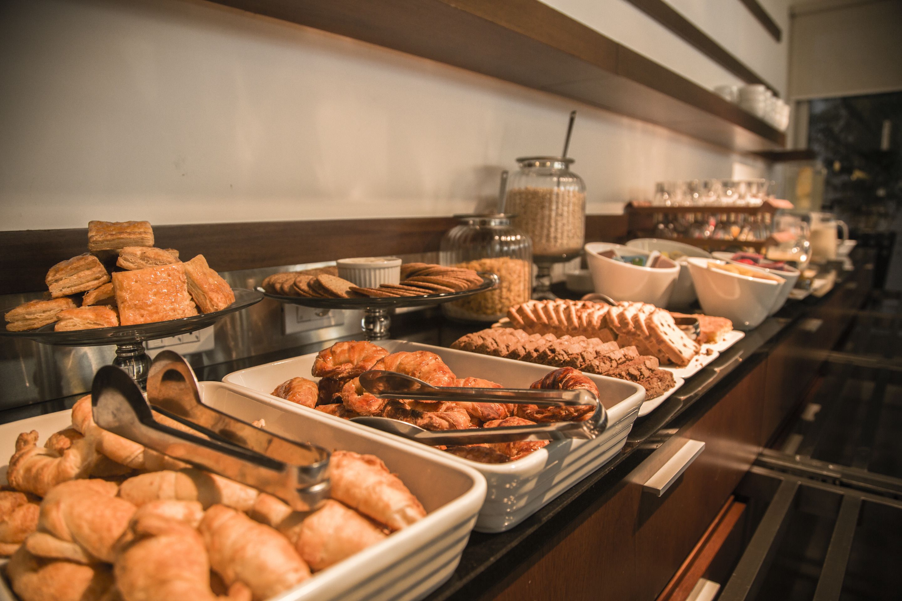 Un bufé con diversos alimentos, incluyendo pasteles, galletas y tazones de comida.