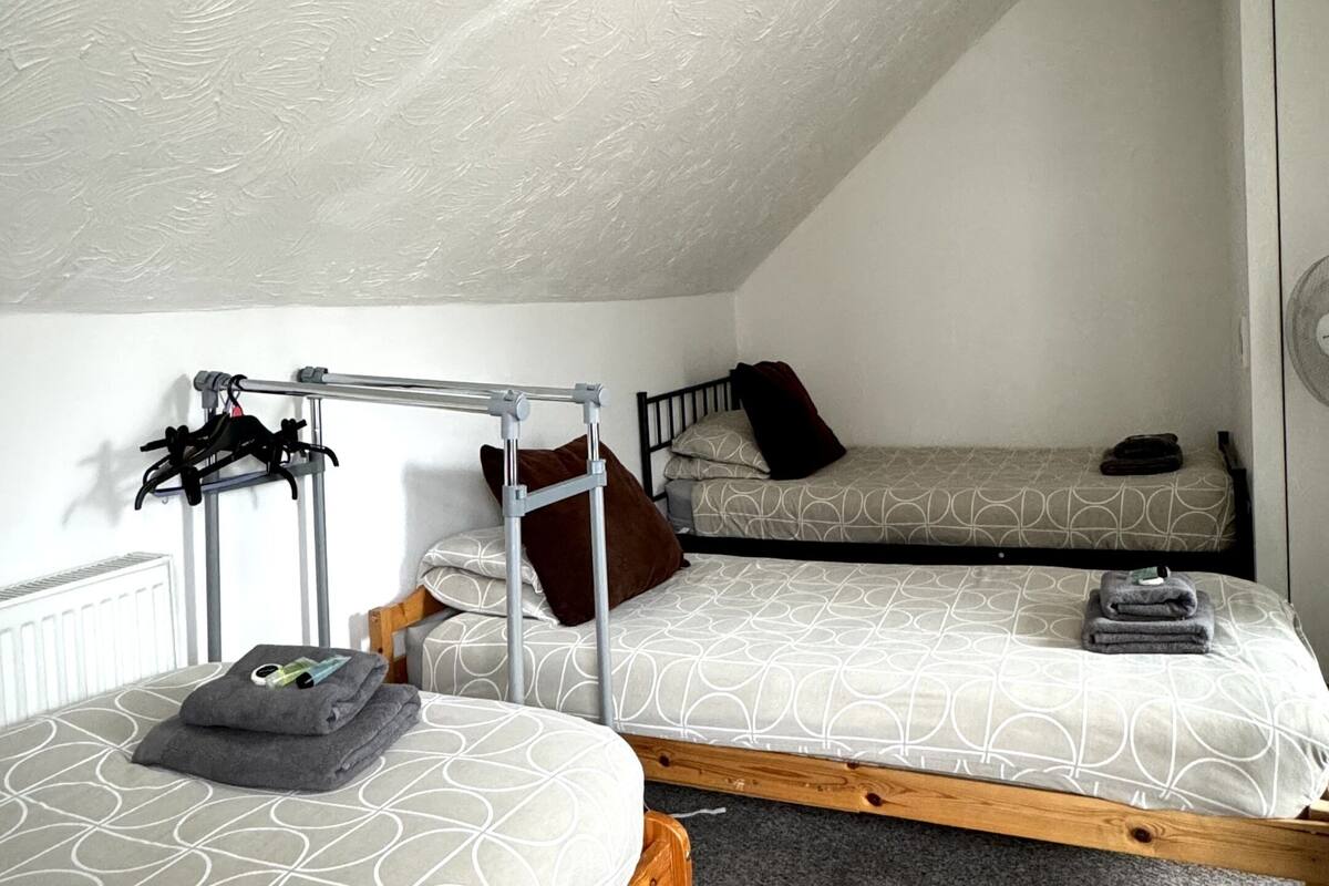 Une petite pièce agréable, dotée de deux lits superposés, d’un radiateur, d’un luminaire au plafond et d’un porte-vêtements.