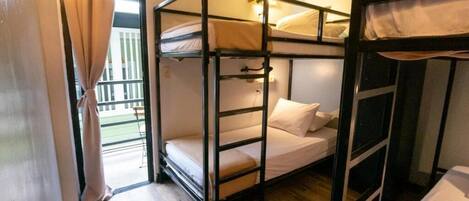 Habitación con literas, ventana, cortina y piso de madera.