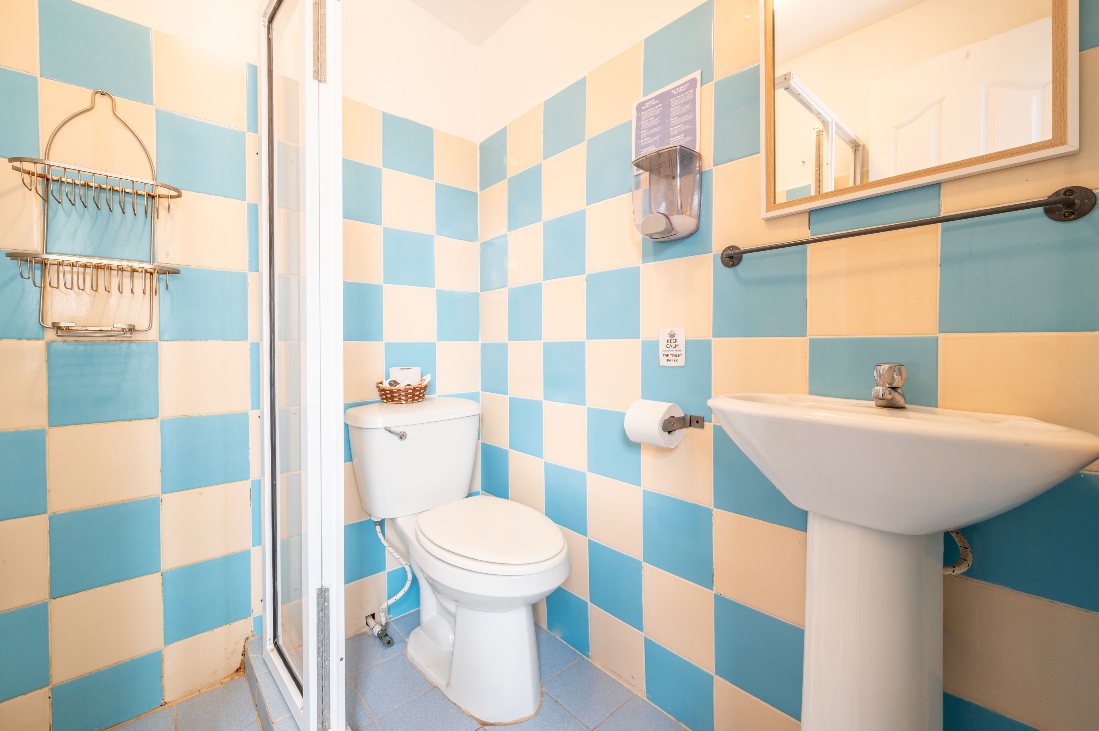 A bathroom with a toilet, sink, and a shower area.