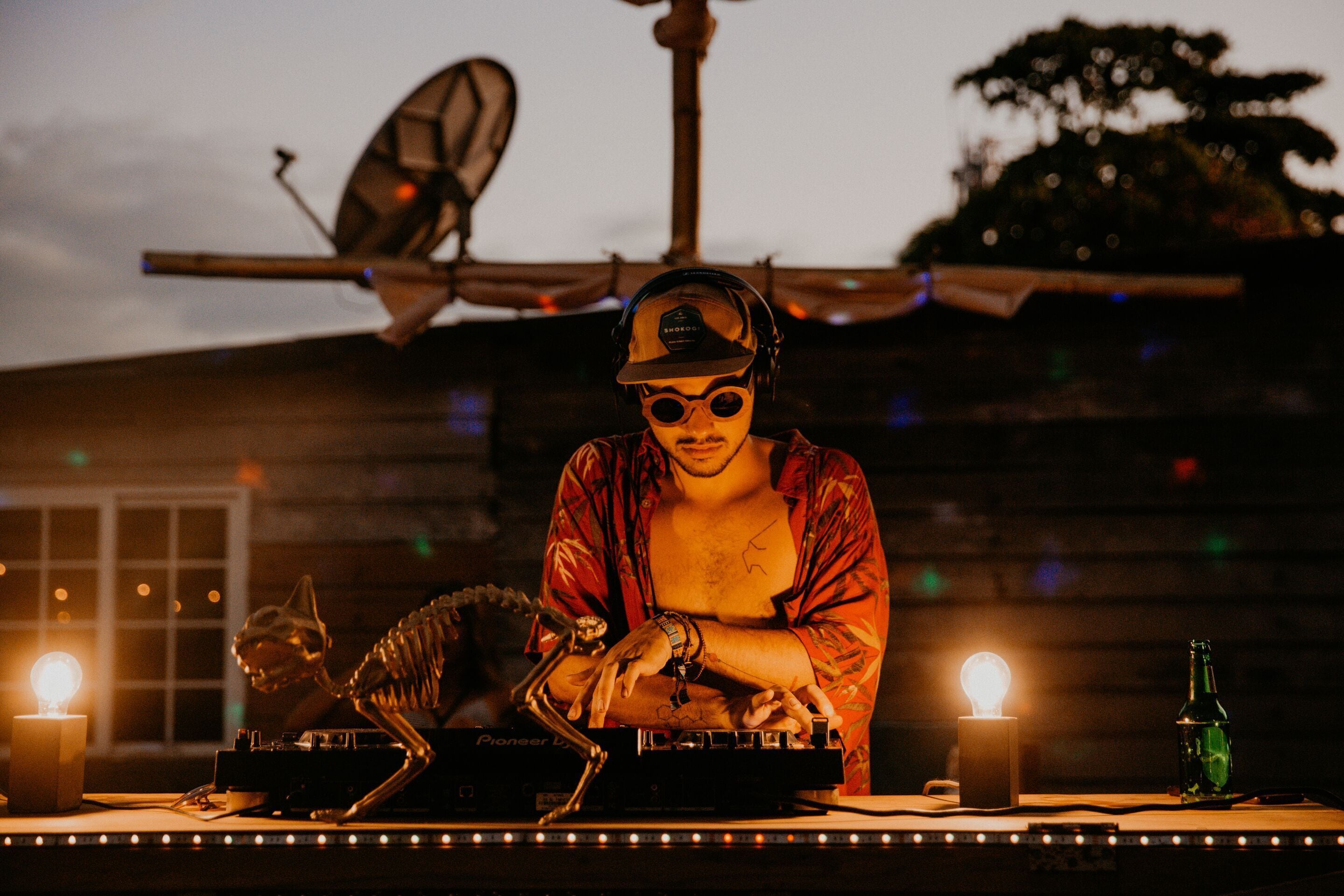A DJ booth with a skeleton figure, a bottle, and a light.