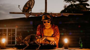 A DJ booth with a skeleton figure, a bottle, and a light.