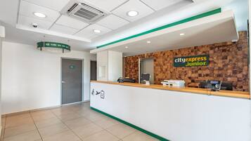 A clean reception area with a wooden accent wall, a reception desk, and a sign for CityExpress Junior.