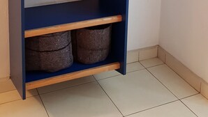 A blue wardrobe with multiple shelves and a hanging rod.