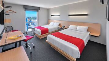 Ein Hotelzimmer mit zwei Betten, einem Schreibtisch, einem Stuhl und einem Fenster mit Blick.