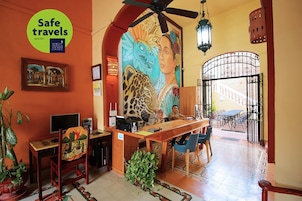 A reception area with a desk, chairs, a computer, and a mural on the wall.