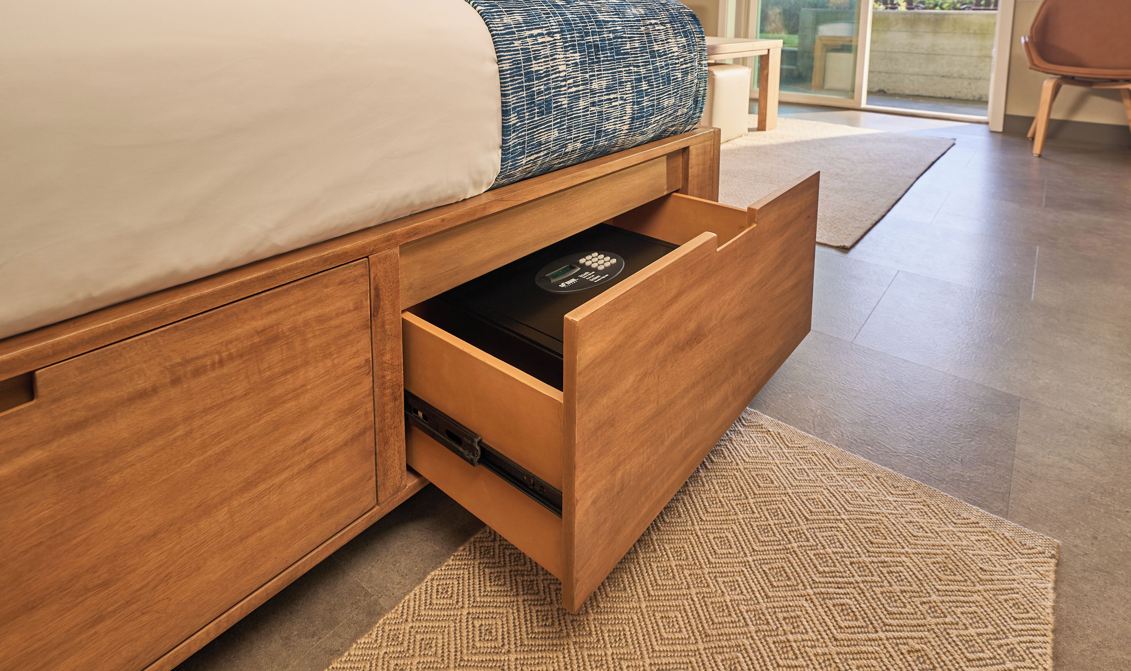 A bed with a wooden headboard and a built-in drawer with a control panel.