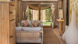 Une pièce chaleureuse avec un canapé, un meuble en bois, un grand vase et une petite table.
