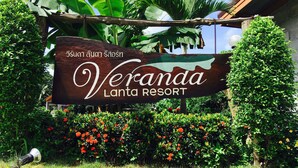 Señal del resort Veranda Lanta, con un jardín tropical de fondo.
