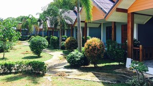 Un hilera de edificios tipo bungalow con un sendero de jardín que lleva a la entrada.