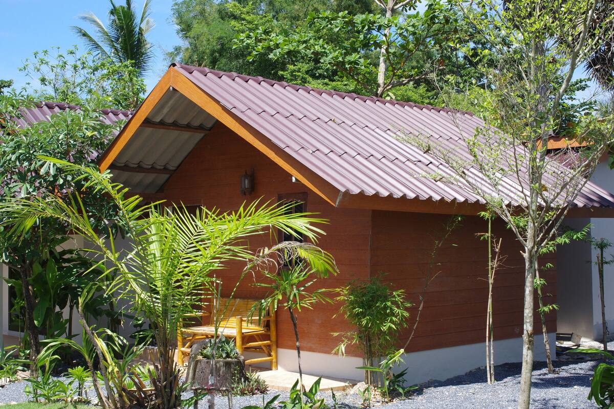 A small, single-story building with a sloped metal roof and a wooden porch.