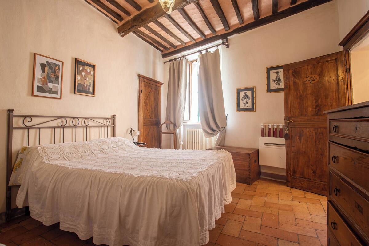 Un dormitorio con una cama grande, un armario de madera y un radiador.