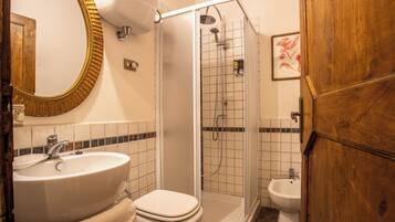 Un bagno con lavandino, WC, doccia e bidet.