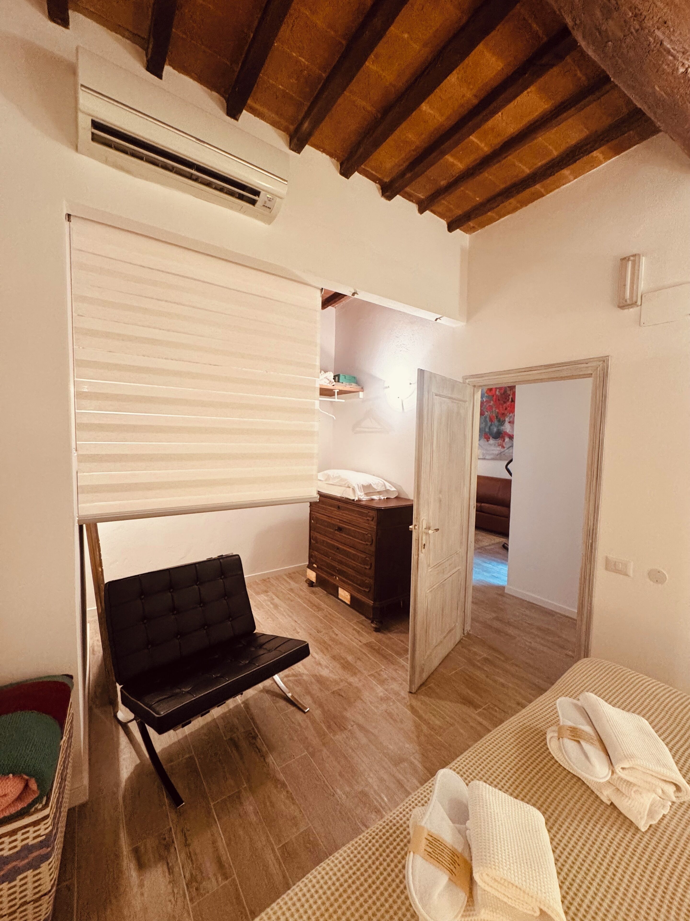 Ein Schlafzimmer mit einem Bett, einem Sessel, einem Schminktisch und einem Kleiderschrank.