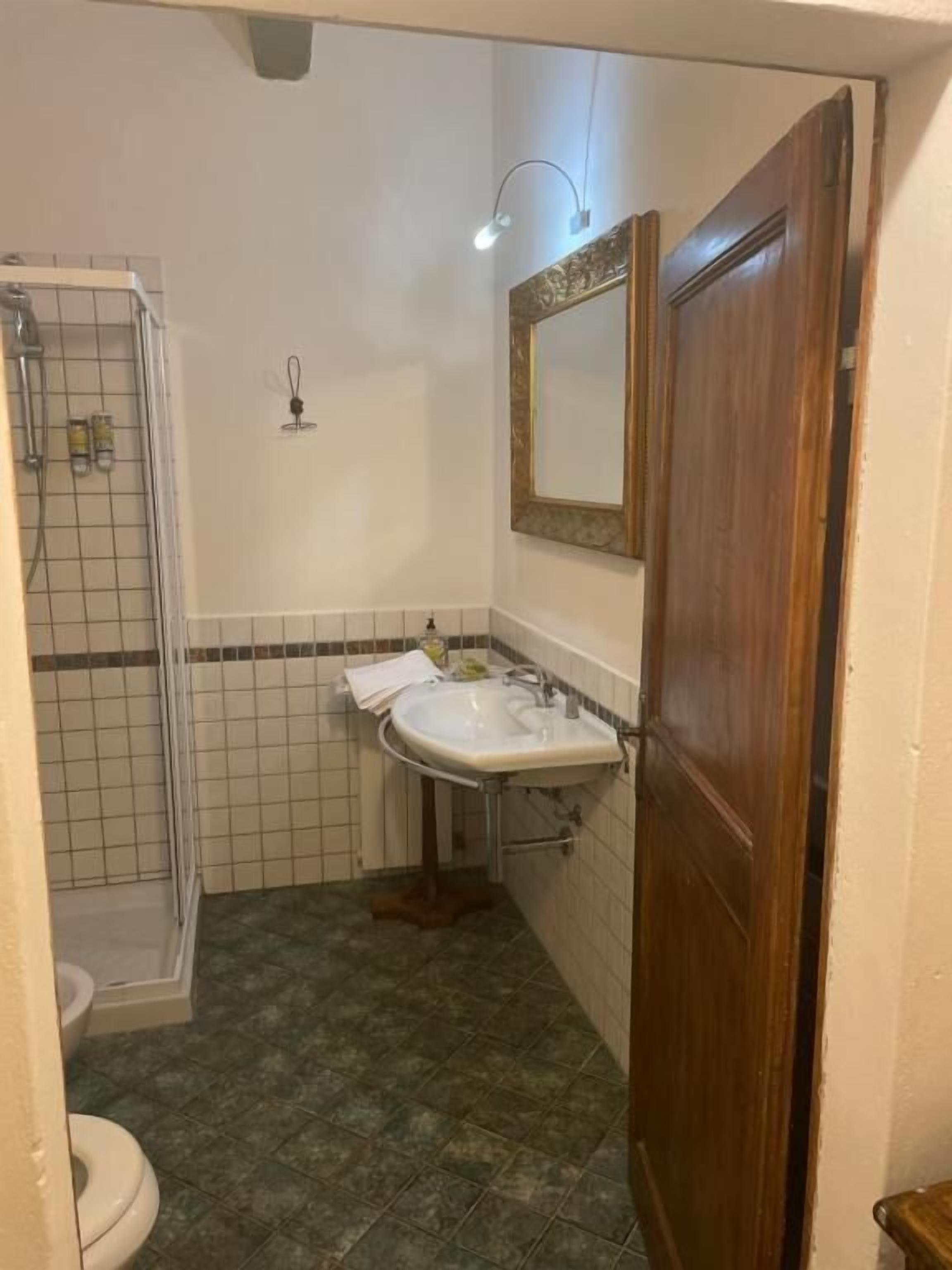 A bathroom with a shower, a sink, and a toilet.
