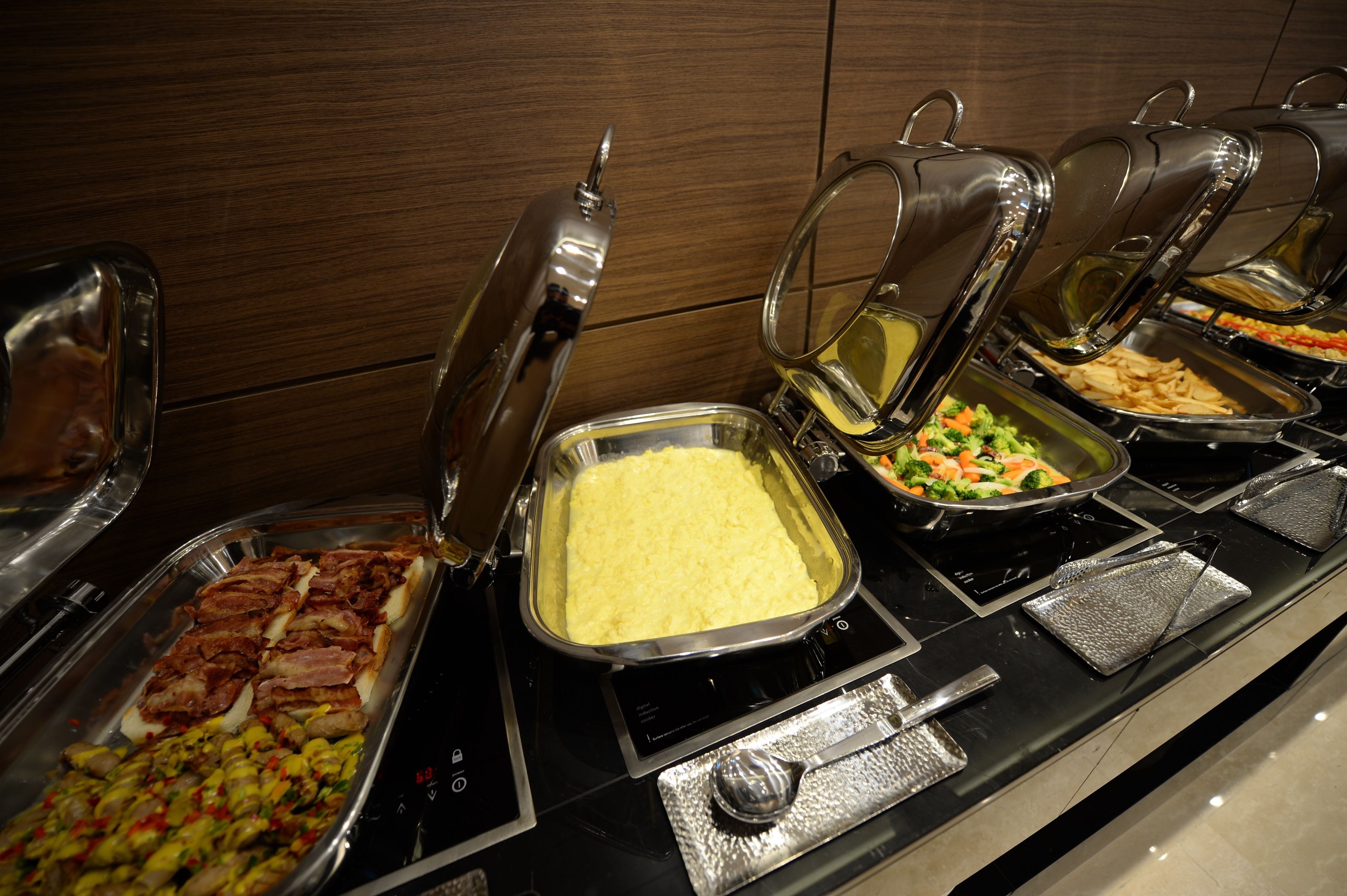 A buffet with various food options including meats, salads, and a casserole dish.