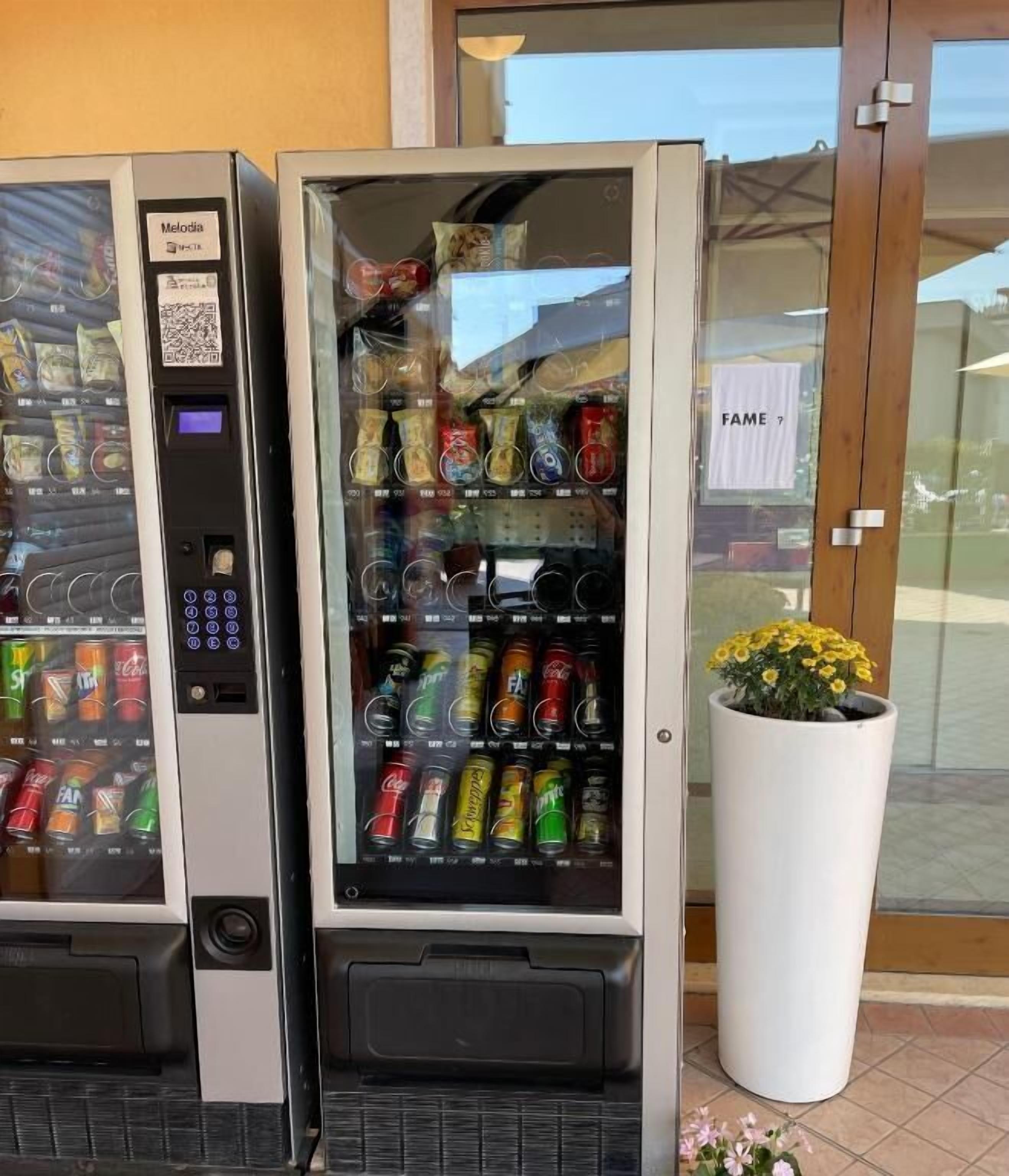 A vending machine with a QR code and a selection of beverages.