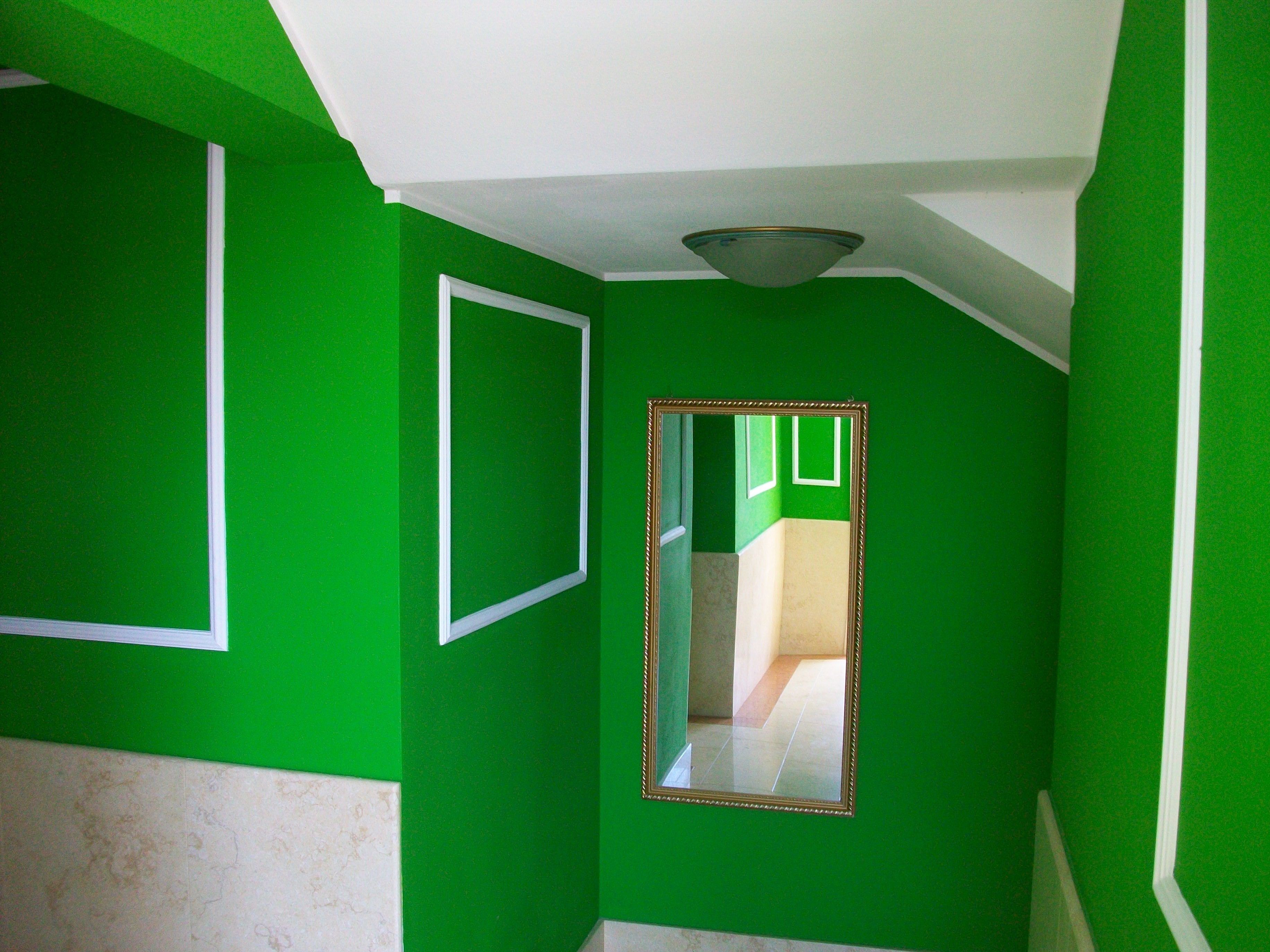 A hallway with green walls and white trim.