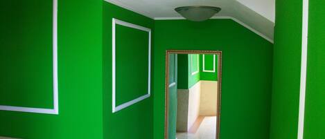 A hallway with green walls and white trim.