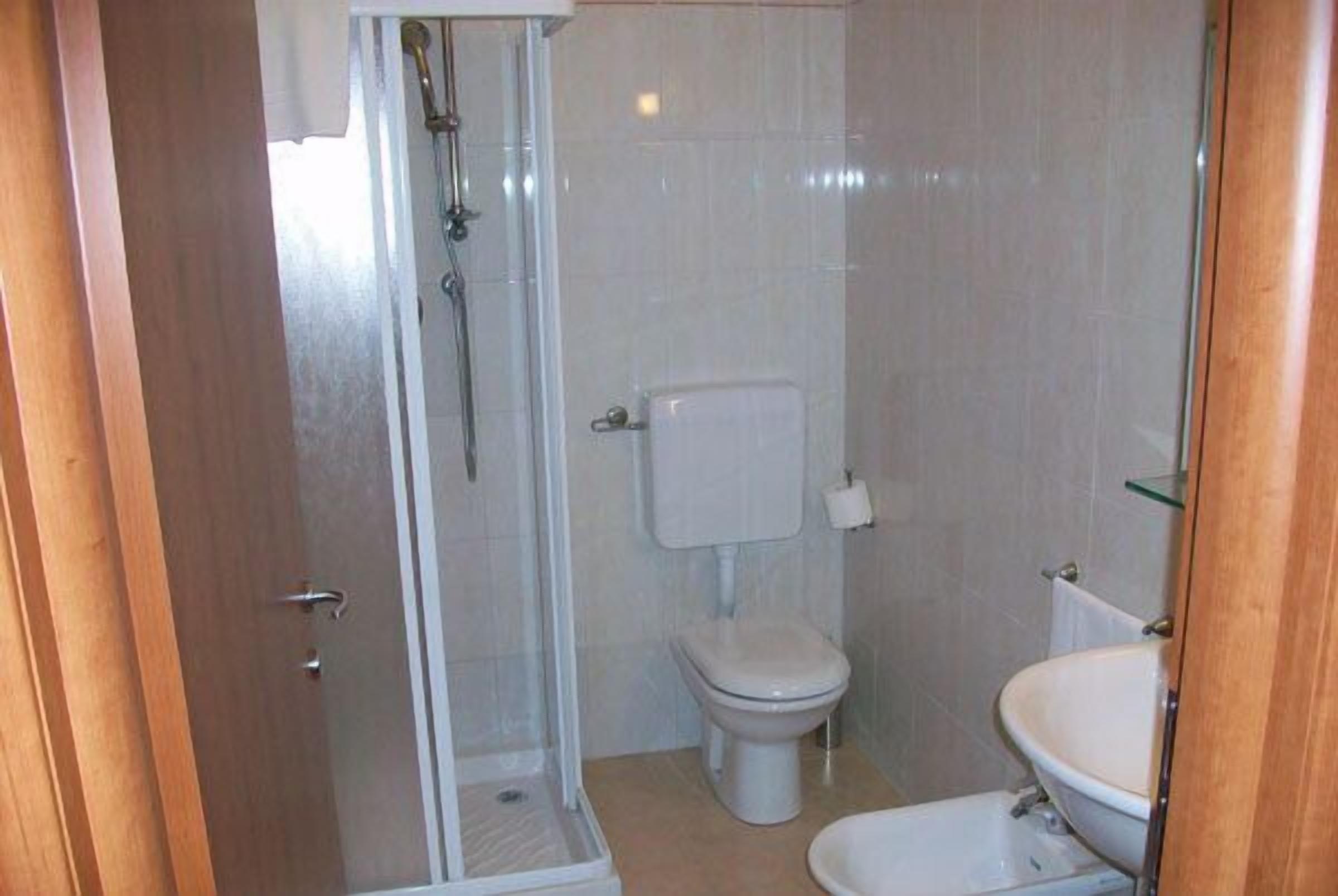 Ein kleines Badezimmer mit Toilette, Waschbecken und Duschkabine.