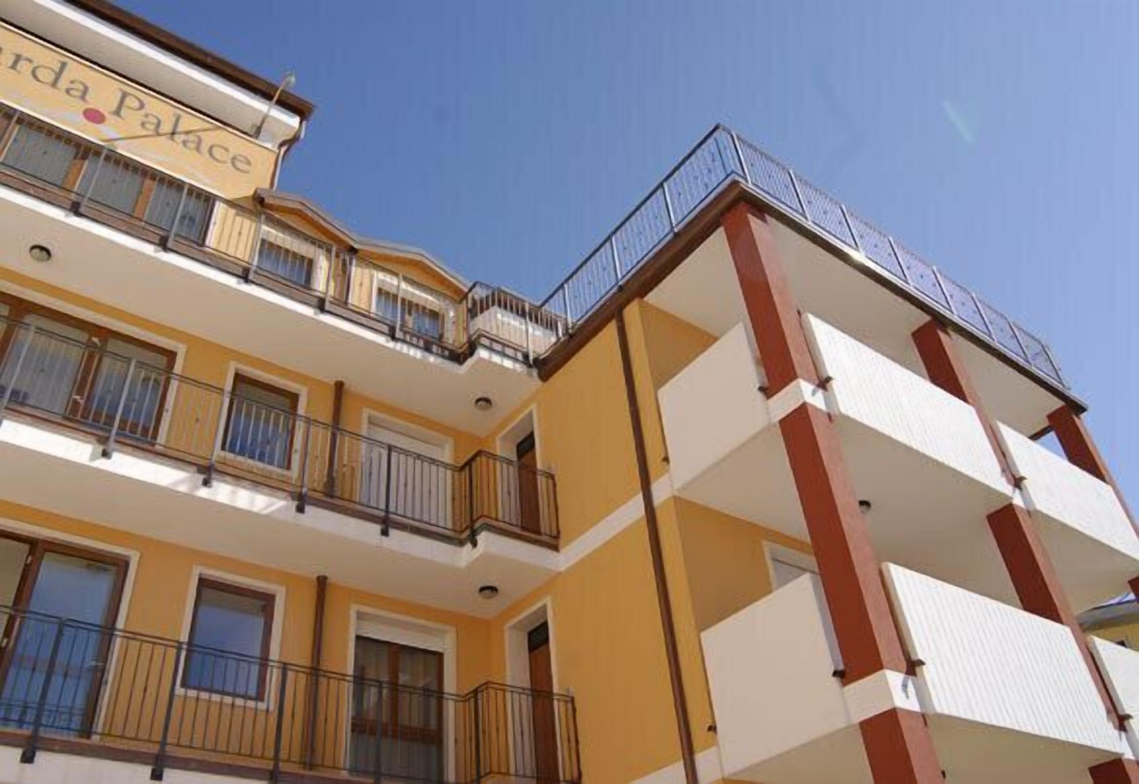 A multi-story hotel with balconies and a sign reading "Villa Palace".