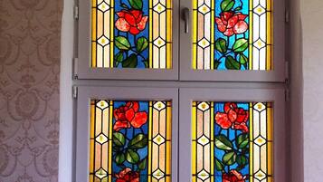 A double door with stained glass windows featuring floral designs.