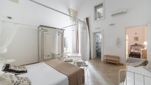 A bedroom with a bed, a wardrobe, a bedside table, and a chair. - Nuvole Barocche (Lecce)