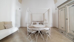 A bedroom with a canopy bed, a white sofa, and a cabinet. - Nuvole Barocche (Lecce)
