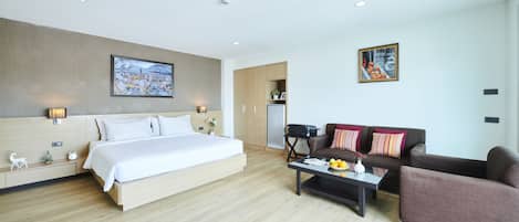 Una habitación de hotel moderna con una cama grande, un sofá, una mesa de centro y un escritorio.
