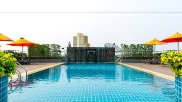 Una piscina al aire libre, sombrillas, sillones reclinables de piscina