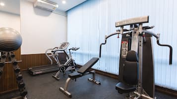 A gym with exercise equipment, a treadmill, and a stationary bike.