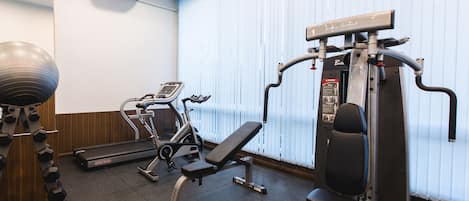 Ett gym med träningsutrustning, ett löpband och en motionscykel.