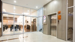 A modern hotel lobby with a glass entrance, a reception desk, and an elevator. - Adelphi Pattaya (Pattaya)
